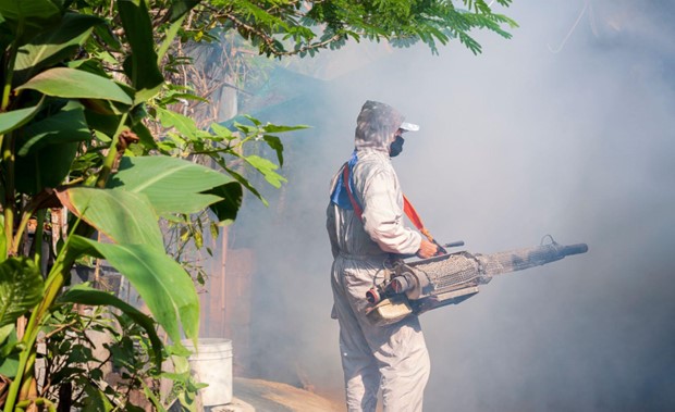 Man in hazmat suit spraying area